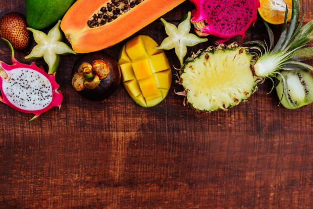 istock Tropical fruits on wooden background 1136496893