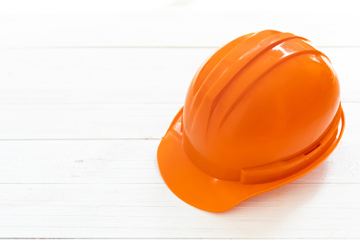 Engineer or foreman safety helmet on white wooden background.