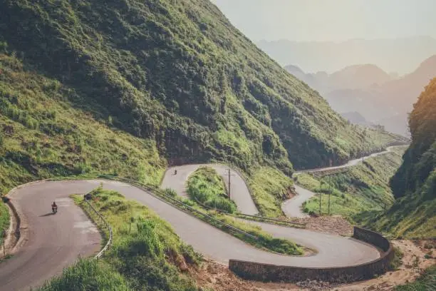 Photo of Beautiful natural scenery of the road that bends more green tropical forest mountain at North Vietnam.Aerial view landscape for adventure travel.