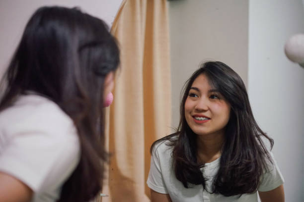 istock an young asian woman in a mirror 1136506459