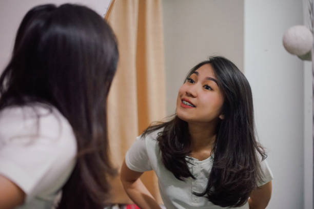 istock an young asian woman in a mirror 1136506461