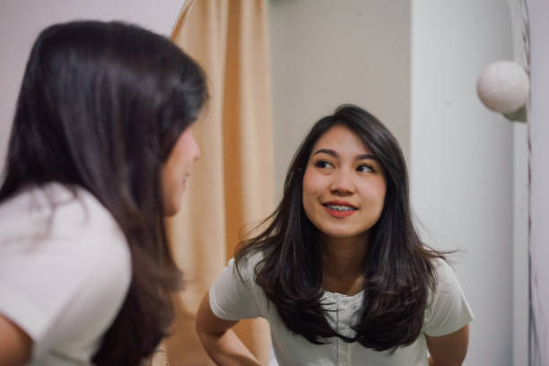istock an young asian woman in a mirror 1136506515