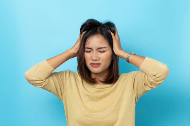 istock young woman having headache on white background 1136506613