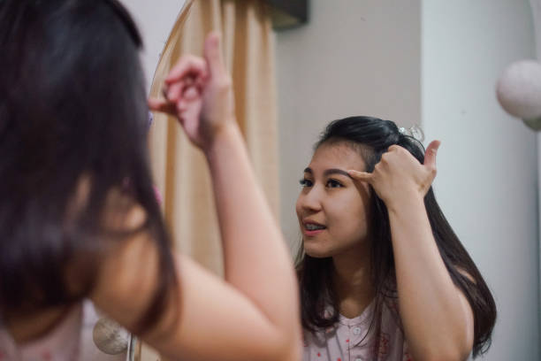 istock an young asian woman is using an eyebrow pencil 1136506654