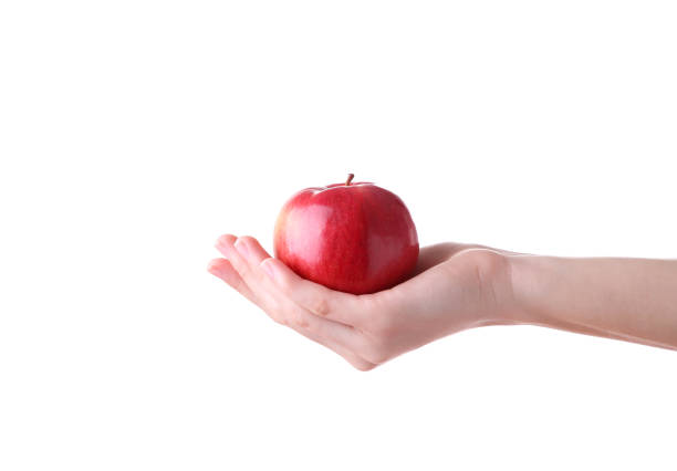 istock Female hand holding red apple isolated on white background 1136510322