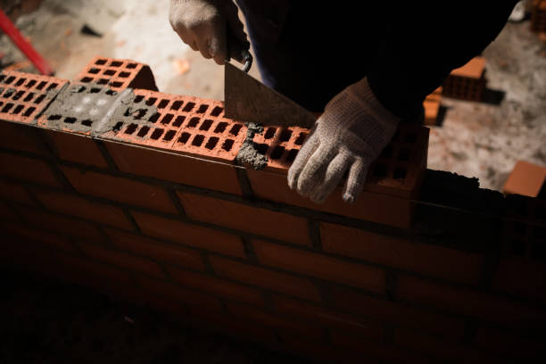 istock Closeup hand professional construction worker laying bricks in new industrial site 1136515321