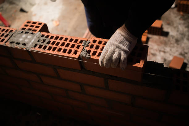 istock Closeup hand professional construction worker laying bricks in new industrial site 1136515334