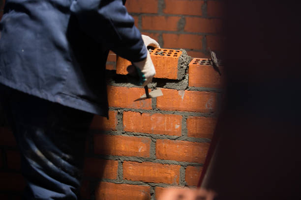 istock Closeup hand professional construction worker laying bricks in new industrial site 1136515344