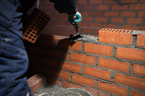 istock Closeup hand professional construction worker laying bricks in new industrial site 1136515469