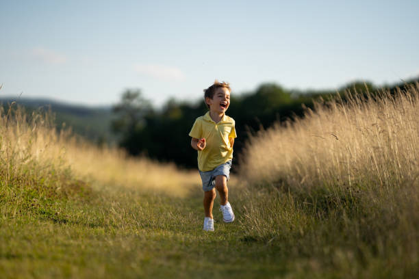 istock joyful little boy running on summer meadow 1136516560