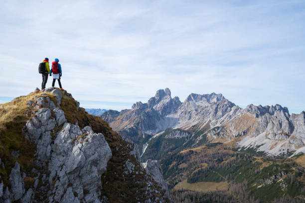 two hikers standing together high up with amazing view mountain range - hiking mountain mountain climbing mountain peak imagens e fotografias de stock