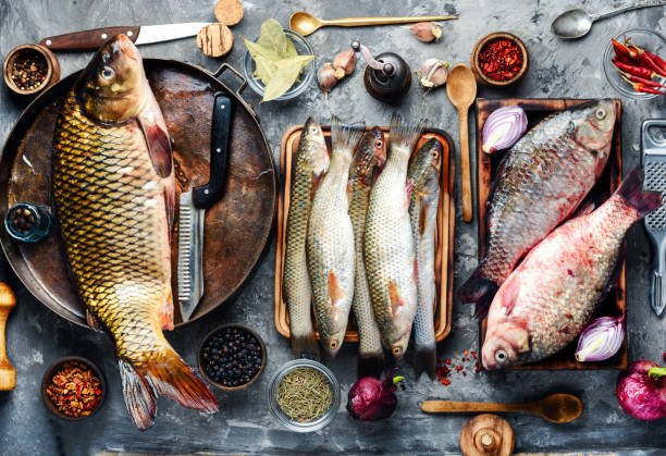 Fresh fish and ingredients Fresh raw fish on wooden cutting board.Raw fish with spices for cooking.Fish background fish food stock pictures, royalty-free photos & images