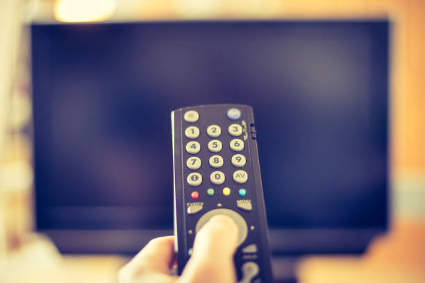 istock Male hand is holding TV remote control, smart TV. 1136522955