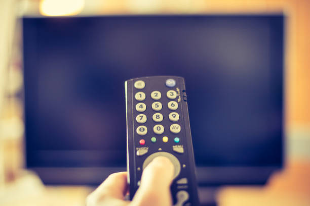 istock Male hand is holding TV remote control, smart TV. 1136523049