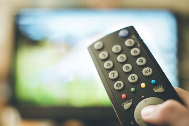 istock Male hand is holding TV remote control, smart TV. 1136523392