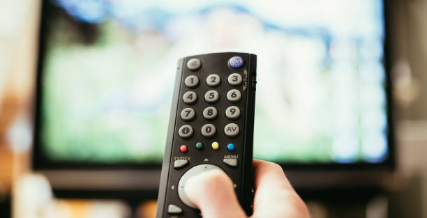 istock Male hand is holding TV remote control, smart TV. 1136523507