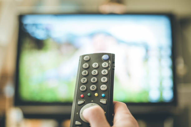 istock Male hand is holding TV remote control, smart TV. 1136524196