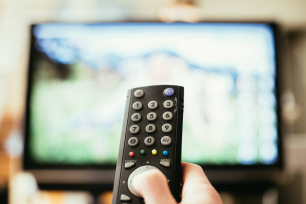 istock Male hand is holding TV remote control, smart TV. 1136524197