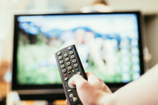 istock Male hand is holding TV remote control, smart TV. 1136524203