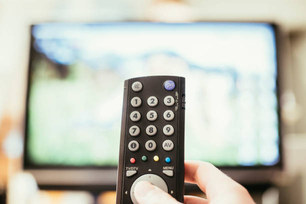 istock Male hand is holding TV remote control, smart TV. 1136524307