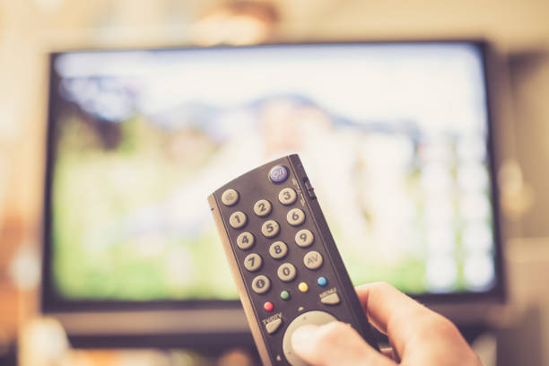 istock Male hand is holding TV remote control, smart TV. 1136524323