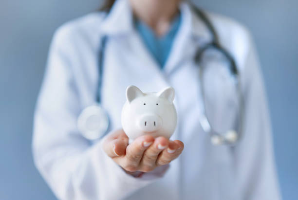 Doctor holding piggy bank Hospital, Healthcare And Medicine, Currency, Medical Insurance, Doctor medical insurance stock pictures, royalty-free photos & images