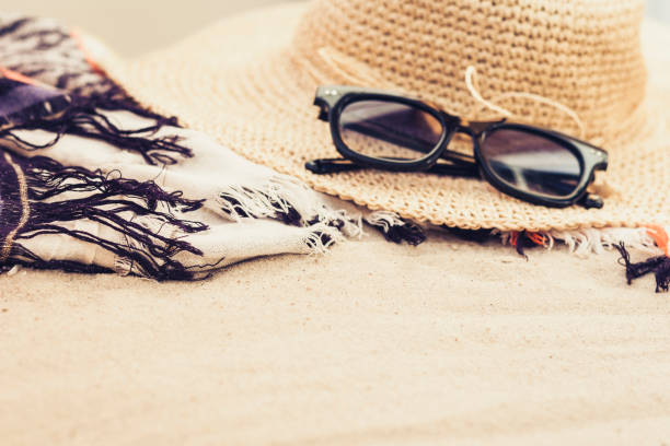Vintage summer wicker straw beach bag, sun glasses and bag on the sand