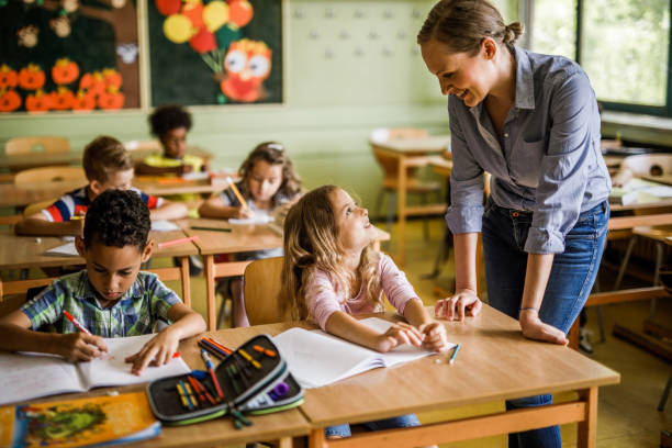 istock Happy teacher communicating with her student during a class at elementary school. 1136539278