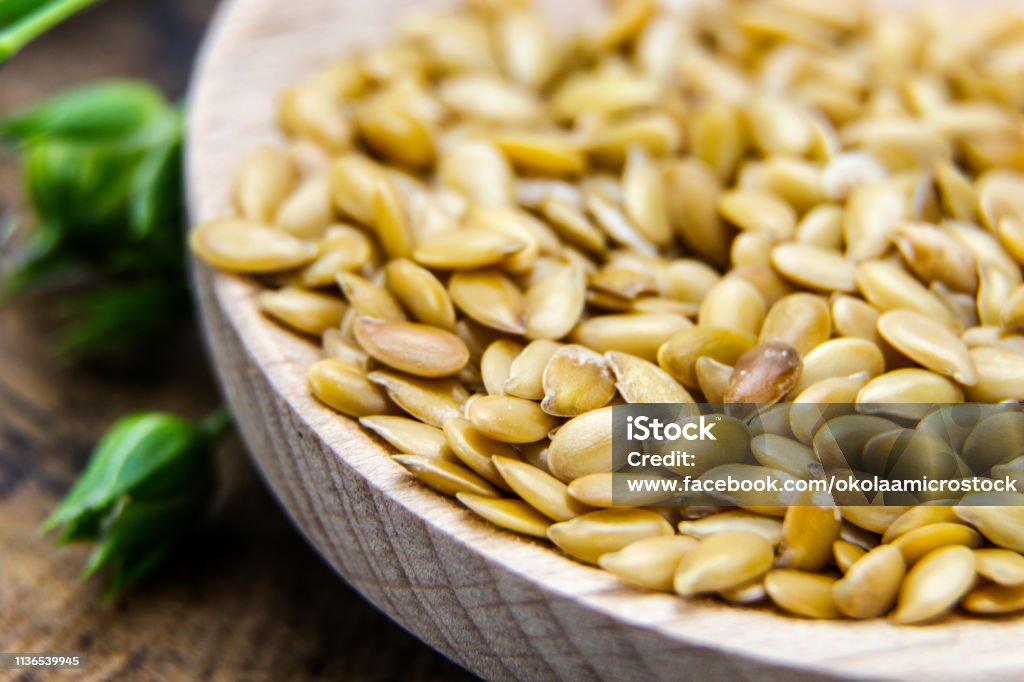 Golden flax seeds wooden surface closeup Acid Stock Photo