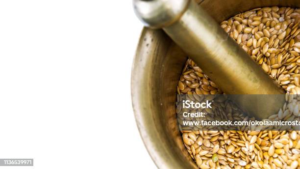 Golden Flax Seeds Inside Bronze Mortar Closeup With Copyspace Stock Photo - Download Image Now