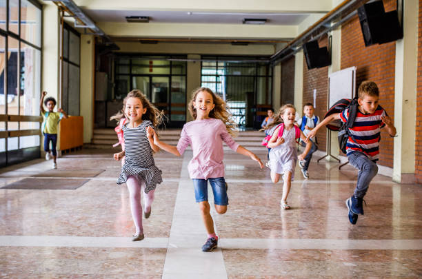 istock Large group of elementary students rushing through the school hallway. 1136541212