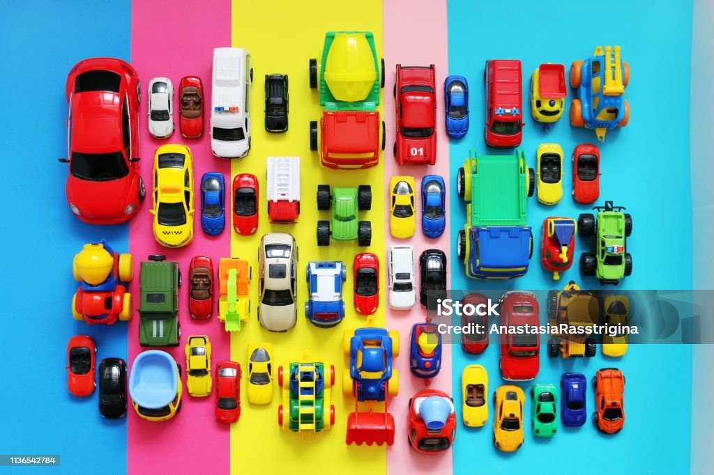 Muchos coches de juguete de colores en el fondo multicolor - Foto de stock de Coche de juguete libre de derechos