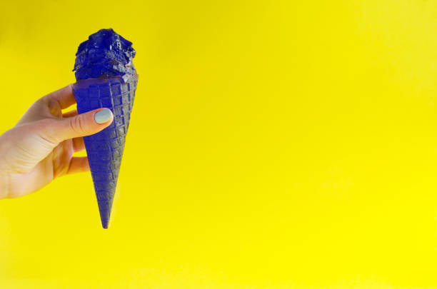 istock Extraordinary colored ice cream against sunny yellow background 1136542982