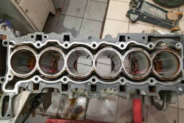 Top view at replacement six cylinder engine used on a crane mounted for installation on a car after a breakdown and repair in a auto service workshop as a guarantee for the dealership