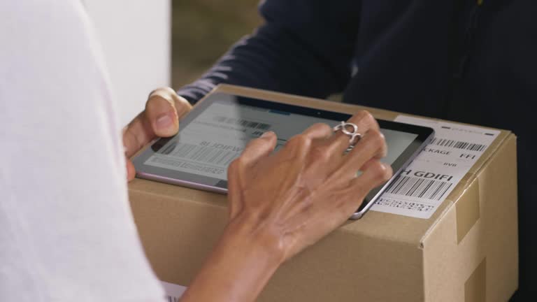 Hands of a woman opening the door and signing for the package