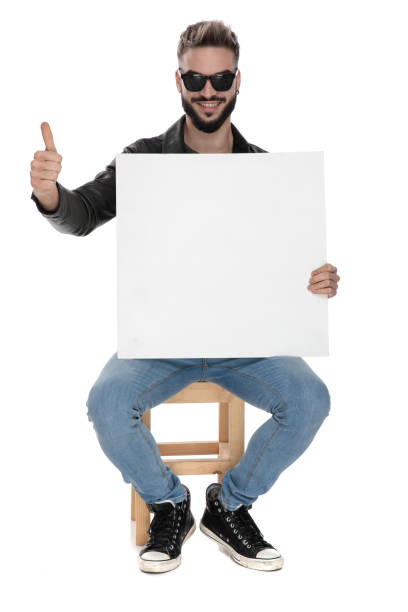 istock man holding blank billboard on hand while showing ok gesture 1136544483