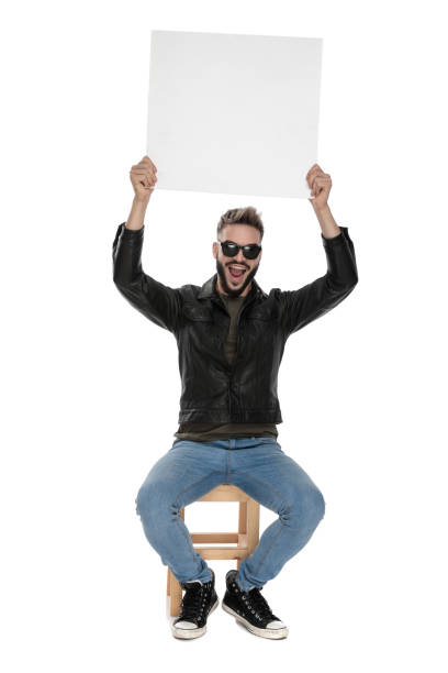 istock man holding blank billboard up in the air while smiling 1136544519