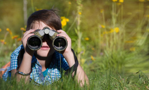 istock Boy young researcher exploring with binoculars environment in summer garden 1136544894
