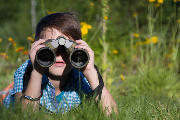 istock Boy young researcher exploring with binoculars environment in summer garden 1136544949