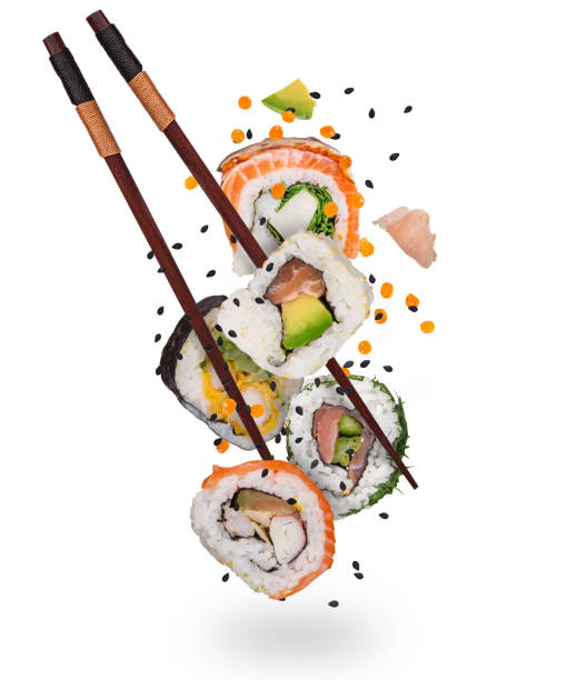 Pieces of delicious japanese sushi frozen in the air. Pieces of delicious japanese sushi frozen in the air. Isolated on white background chopsticks stock pictures, royalty-free photos & images