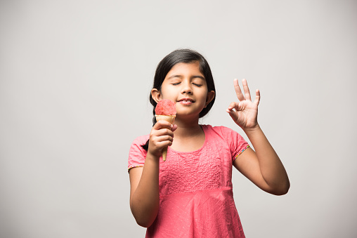 cute little Indian girl eating ice cream in cone