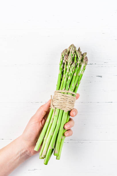 istock Fresh green asparagus in woman hands 1136547957