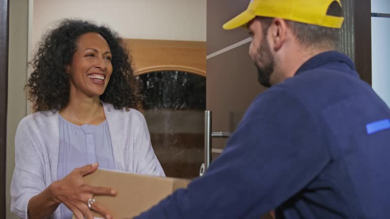 Woman signing the digital POD before the male courier hands her the package at the front door