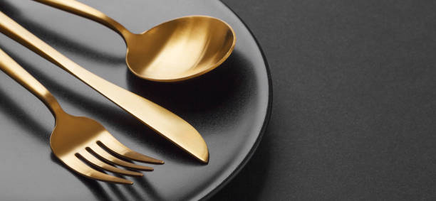 istock Gold cutlery set on black background 1136551840