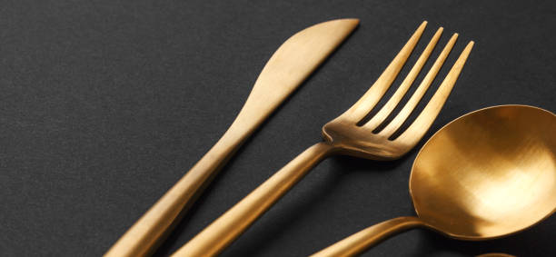 istock Gold cutlery set on black background 1136552034