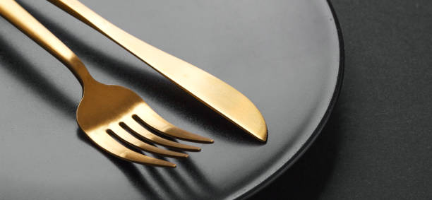 istock Gold cutlery set on black background 1136553133