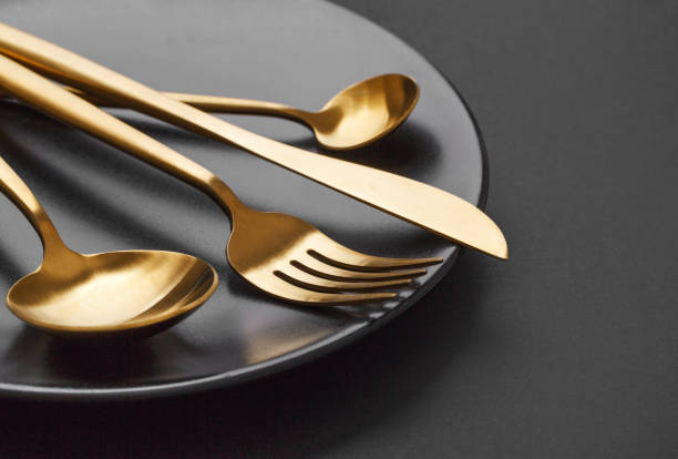 istock Gold cutlery set on black background 1136553748