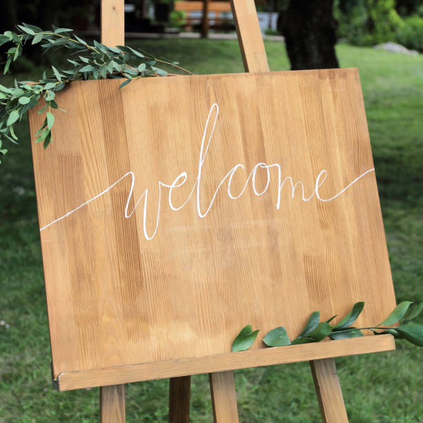 istock Wooden easel with a board. On the board written white paint - Welcome 1136555043