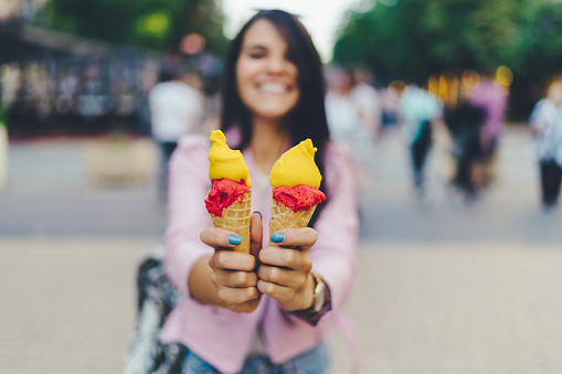 Happy gen z girl showing colorful ice-creams to the camera