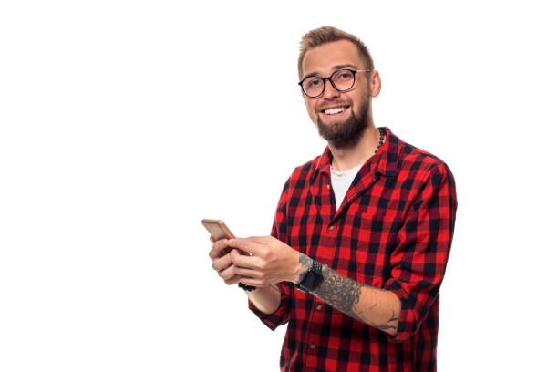 istock Message to friend. Handsome young man using phone with smile while standing againstwhite background 1136556985